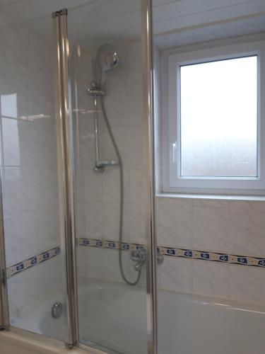 y baño con ducha y ventana. en Ferienhaus Gossel, en Bad Wildungen