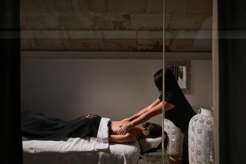 a woman is giving a man a massage at Boutique Hotel Posada Terra Santa in Palma de Mallorca