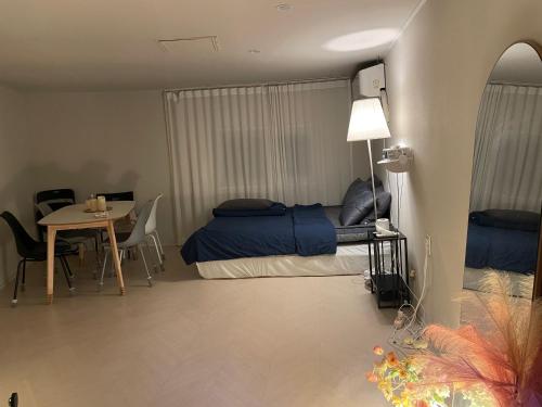 een slaapkamer met een bed en een tafel met stoelen bij Well Plus Guest House in Seoul