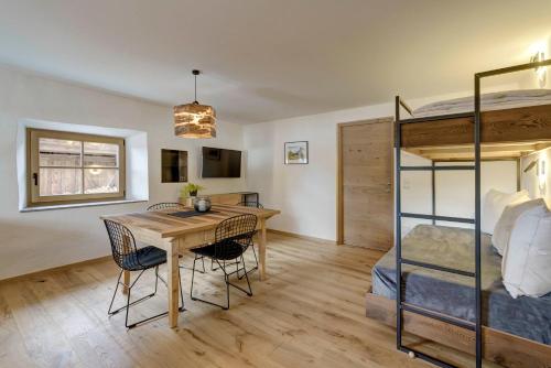 a bedroom with a table and a bunk bed at Stube Biohof Oberzonn in Kastelruth