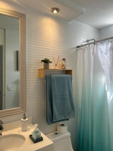 a bathroom with a blue shower curtain and a sink at Mar Private Rooms in Lima