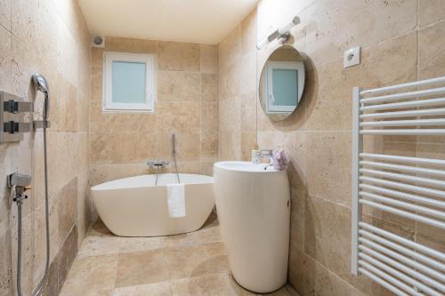 une salle de bain avec une baignoire, un lavabo et un miroir dans l'établissement Unique studio - Central Area, à Paris