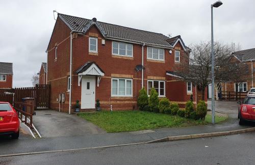 a red brick house with a white door at Lovely 3 Bedroom House Manchester in Manchester