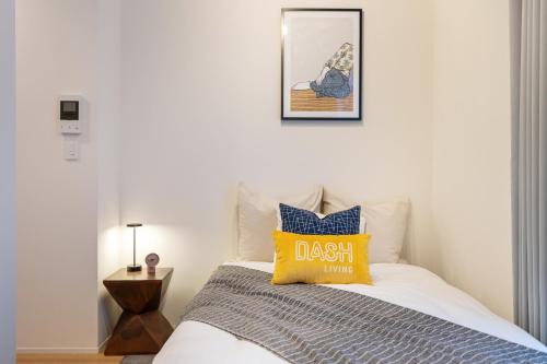 a bedroom with a bed with a yellow pillow at Dash Living Kagurazaka in Tokyo