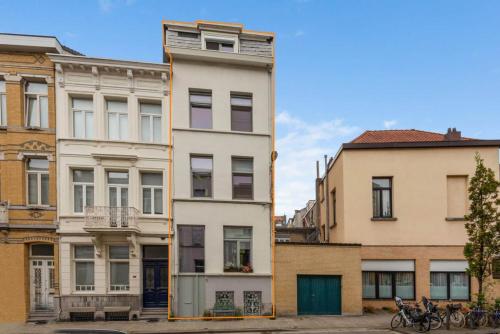 um edifício branco alto em frente a outros edifícios em J1 - Urban studio in Antwerp em Antuérpia