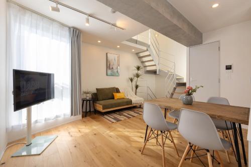 a living room with a dining room table and a television at Dash Living Kagurazaka in Tokyo