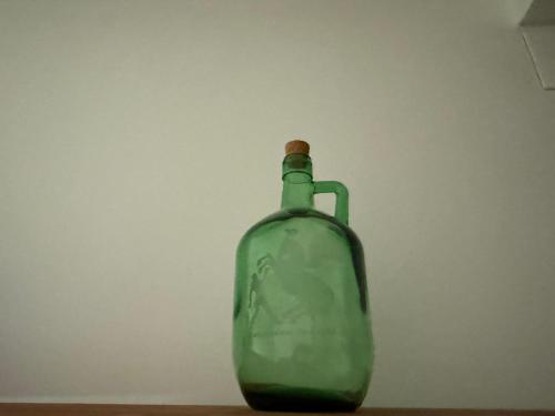 a green glass bottle sitting on top of a table at Apartamento Irene 1 in Caravaca de la Cruz