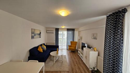 a living room with a blue couch and a table at Airport Residence in Otopeni