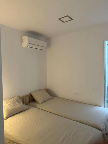 a white room with a bed and a window at Apartamento a 1 minuto de la playa in Castelldefels