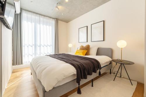 a bedroom with a large bed and a window at Dash Living Kagurazaka in Tokyo