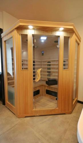 a wooden cabinet with glass doors in a room at La Brique in Yvetot Bocage