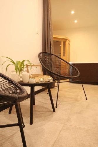 uma sala de estar com uma cadeira e uma mesa em La Brique em Yvetot Bocage