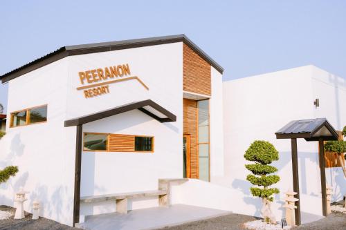 een wit gebouw met een bord voor een Peruaans restaurant bij Peeranon Resort in Ban Nong Khiam