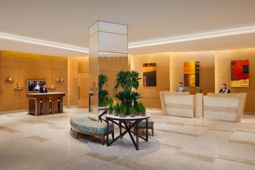 a lobby with a table and a potted plant at Courtyard by Marriott Bhopal in Bhopal
