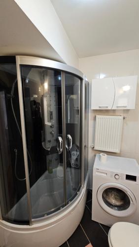 a bathroom with a shower and a washing machine at Airport Residence in Otopeni