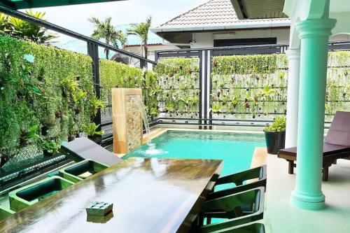 a patio with a pool and a table and chairs at Peacefully Rawai 3 Bedrooms Pool Villa in Rawai Beach