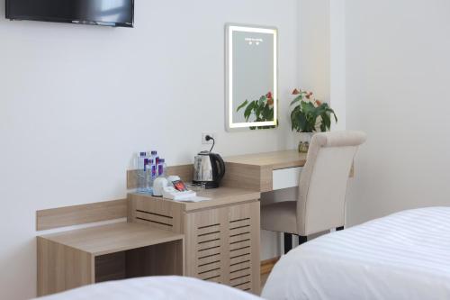 a desk in a bedroom with a bed and a chair at Cong Fu Hotel in Bắc Hà