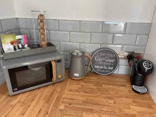 a microwave oven sitting on top of a wooden floor at Riverside Retreat in Hawick