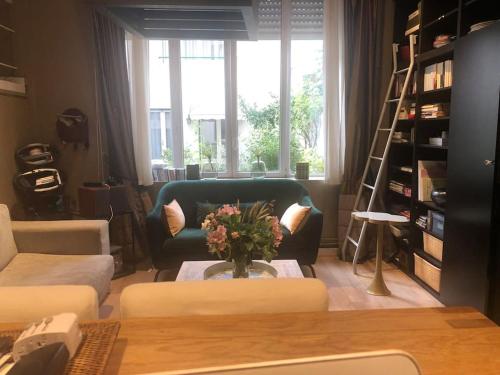 a living room with a couch and a table at Charming flat near Bois de Boulogne Paris in Neuilly-sur-Seine