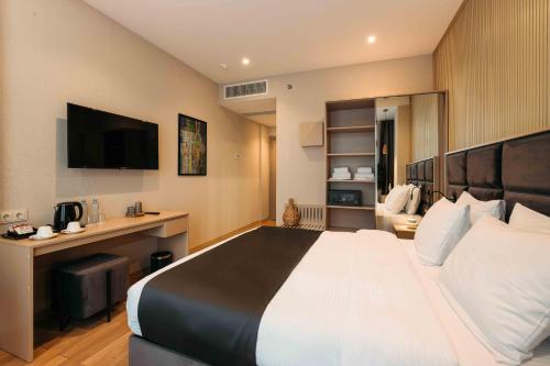 a hotel room with a large bed and a television at Hotel Monday by DNT Group in Tbilisi City