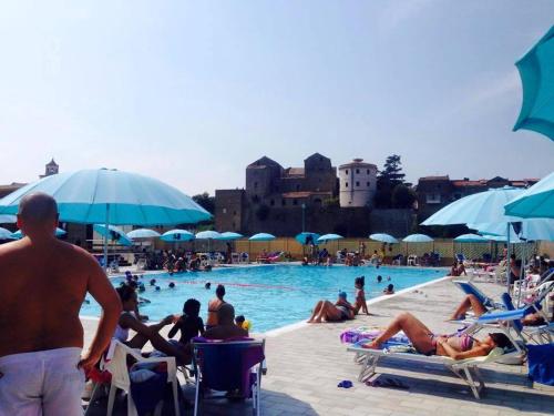 a group of people in a swimming pool with umbrellas at Le Rocce in SantʼAgata deʼ Goti