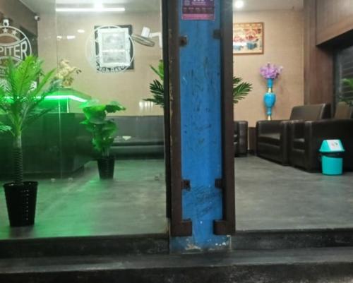 a mirror reflection of a waiting room with plants at Jupiter Beach Resort , Puri in Puri