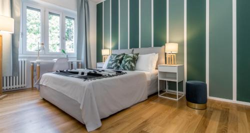 - une chambre avec un lit et un mur vert dans l'établissement ALTIDO Delightful Flats Near CityLife District, à Milan