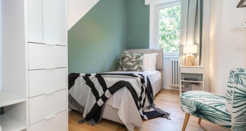 a bedroom with a bed and a chair and a window at ALTIDO Delightful Flats Near CityLife District in Milan