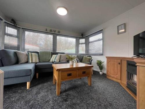 ein Wohnzimmer mit einem Sofa und einem Couchtisch in der Unterkunft Riverview Caravan in Briery Yards