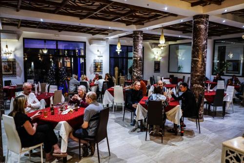 eine Gruppe von Personen, die in einem Restaurant an Tischen sitzen in der Unterkunft Hotel La Perle du Sud in Ouarzazate