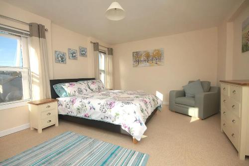 a bedroom with a bed and a chair at 28A Benedict Street in Glastonbury