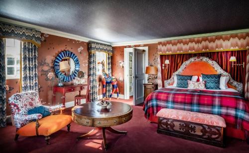 a bedroom with a bed and a table and a chair at The Glenmorangie House in Tain