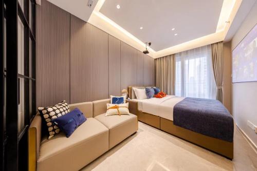 une chambre d'hôtel avec deux lits et un canapé dans l'établissement Excellence International Apartment - Convention & Exhibition Center, à Shenzhen