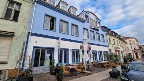 - un bâtiment bleu et blanc avec des tables et des chaises dans l'établissement Ferienwohnung Mark, à Plauen