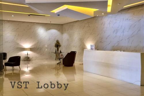 a lobby with a white counter and chairs and a reception desk at Apartment-Serviced & Condo Free pool in Quezon City by Mi'Casa in Manila