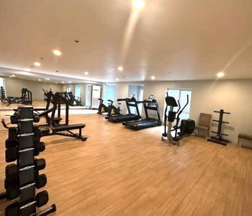 a gym with a bunch of treadms and pilates equipment at Apartment-Serviced & Condo Free pool in Quezon City by Mi'Casa in Manila