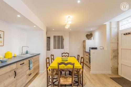 a kitchen with a yellow table and chairs in a kitchen at Le Domaine de Moroges in Moroges
