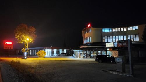 un edificio con un'auto parcheggiata di fronte ad esso di notte di ТРАКАРТ-ПАРК a Plovdiv