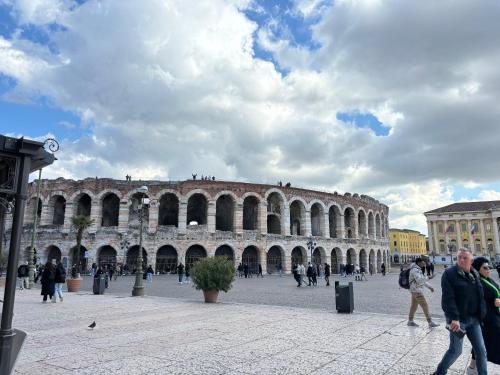 eine Gruppe von Menschen, die vor einem Gebäude spazieren gehen in der Unterkunft Elite Arena in Verona