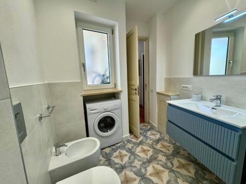 een badkamer met een wasmachine en een wastafel bij Penthouse Duomo in Cefalù