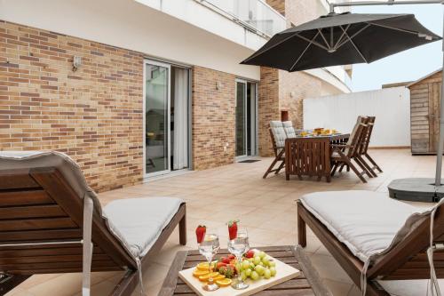 a patio with an umbrella and a table with fruit at Golden Terrace Delight in São Martinho do Porto