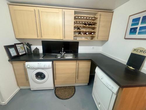 a kitchen with a sink and a washing machine at Fontaine Blanche River View, Large Patio & Garden in Central Brittany with Starlink WiFi in Treffrin