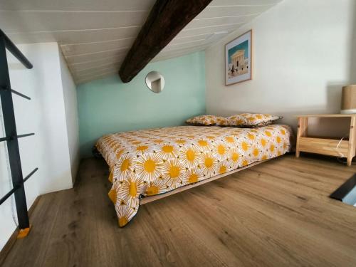 une chambre avec un lit avec un couvre-lit fleuri dans l'établissement Place du marche - Premiere conciergerie, à Nîmes