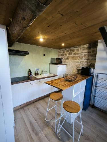 une cuisine avec une table en bois et deux tabourets dans l'établissement Place du marche - Premiere conciergerie, à Nîmes