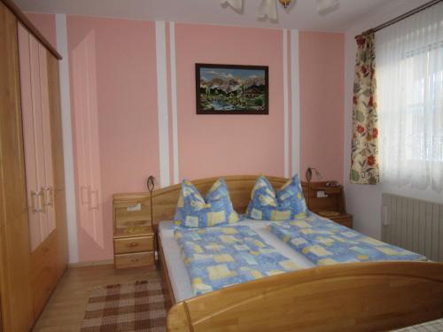 una camera da letto con un letto con cuscini blu e gialli di Haus Margarete a Lackenhof