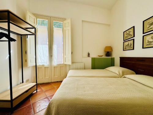 een slaapkamer met 2 bedden en een raam bij Penthouse Duomo in Cefalù