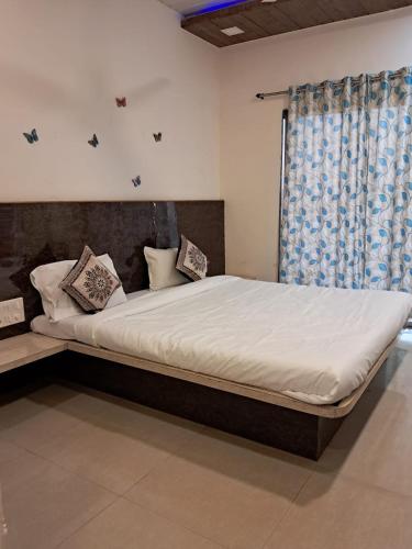 a large bed in a room with a window at Tulsi Villa Bunglow in Mahabaleshwar