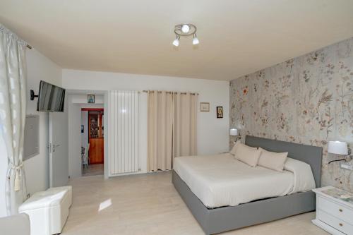 a bedroom with a bed and a wall with floral wallpaper at Il Paradiso sul Mare Apartment in Scala