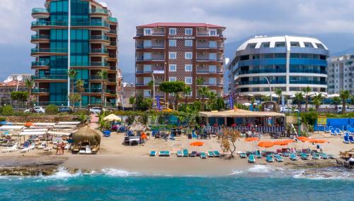 a beach with chairs and umbrellas and buildings at CLUB BAYAR BEACH HOTEL in Alanya