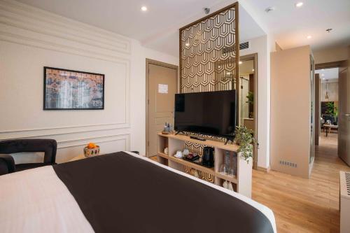 a bedroom with a bed and a flat screen tv at Hotel Monday by DNT Group in Tbilisi City